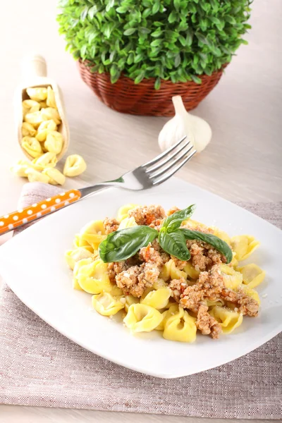 Tortellini met vlees saus en basilicum — Stockfoto