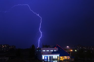 Severe lightning storm over a city buildings clipart