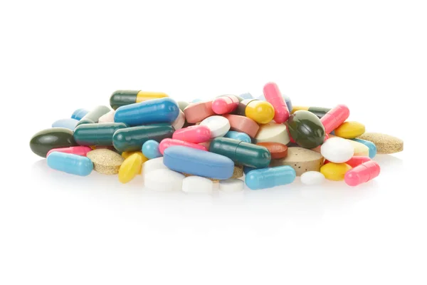 Таблетки и разноцветная капсульная куча — стоковое фото