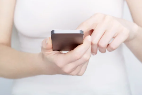 Close up of woman in white using a smartphone — Stock Photo, Image