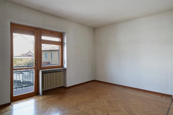 Camera vuota con pavimento in legno e pareti bianche sporche — Foto Stock