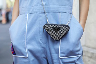 MİLAN, İTALYA 24 EYLÜL 2021: Prada defilesinden önce mücevherlerle dolu küçük, üçgen Prada çantalı kadın, Milan Moda Haftası tarzı