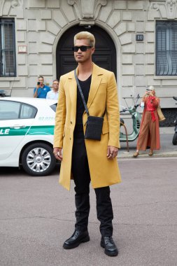 MILAN, İtalya - 25 Eylül 2021 Salvatore Ferragamo defilesinden önce sarı ceketli ve siyah güneş gözlüklü Ross Butler, Milan Moda Haftası tarzı