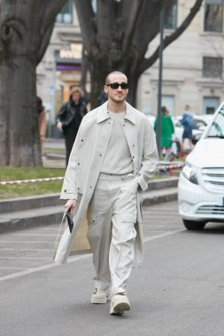 MILAN, İtalya - 24 Şubat 2022: Emporio Armani defilesinden önce bej renkli trençkot ve pantolon giyen adam, Milan Moda Haftası sokak stili