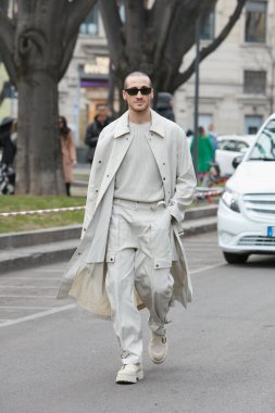 MILAN, İtalya - 24 Şubat 2022: Emporio Armani defilesinden önce bej renkli trençkot ve pantolon giyen adam, Milan Moda Haftası sokak stili