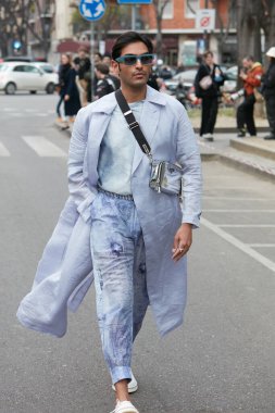 MILAN, İTALYA - 24 Şubat 2022: Emporio Armani defilesinden önce açık mor trençkotlu, pantolonlu ve gümüş renkli Prada çantalı adam, Milan Moda Haftası tarzı