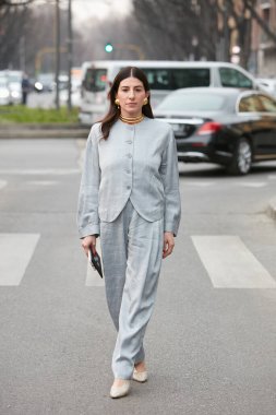 MILAN, İTALYA - 24 Şubat 2022: Kare desenli ve altın kolyeli soğuk gri ceketli ve pantolonlu kadın Emporio Armani moda defilesinden önce, Milan Moda Haftası tarzı