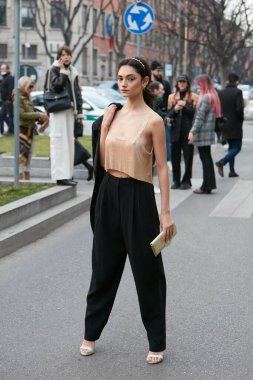 MILAN, İtalya - 24 Şubat 2022: Emporio Armani defilesinden önce altın metalik bluzlu ve siyah pantolonlu kadın, Milan Moda Haftası tarzı