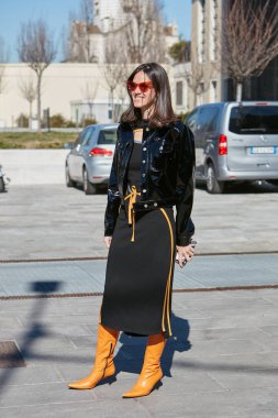 MİLAN, İTALYA 23 Şubat 2022: Turuncu güneş gözlüklü ve deri çizmeli kadın Marco Rambaldi moda defilesinden önce, Milan Moda Haftası tarzı