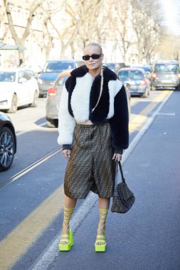 MILAN, İTALYA 23 Şubat 2022: Fendi defilesinden önce kahverengi Fendi etekli ve sarı floresan ayakkabılı kadın, Milan Moda Haftası tarzı