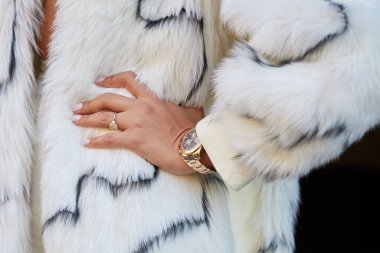 MILAN, İTALYA 23 Şubat 2022: Altın Rolex Daytona, Fendi defilesinden önce pırlanta ve beyaz kürklü kadın, Milan Moda Haftası tarzı