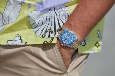 MILAN, ITALY - JUNE 18, 2022: Man with Rolex Subariner watch with blue dial, gold and steel before MSGM fashion show, Milan Fashion Week street style