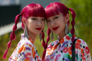 MILAN, ITALY - JUNE 18, 2022: Amiaya, Ami and Aya Suzuki with floral dress before MSGM fashion show, Milan Fashion Week street style