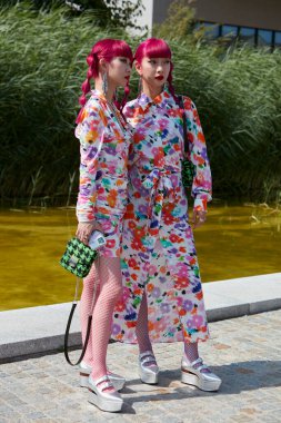 MILAN, ITALY - JUNE 18, 2022: Amiaya, Ami and Aya Suzuki with floral dress before MSGM fashion show, Milan Fashion Week street style