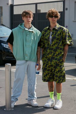 MILAN, ITALY - 18 Haziran 2022: MSGM defilesinden önce açık yeşil ceketli, kot pantolonlu ve sarı floresan çoraplı erkekler, Milan Moda Haftası tarzı