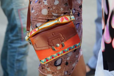 MILAN, ITALY - 18 Haziran 2022: Kahverengi ve turuncu renkli Paula Cademartori çantalı kadın ve Milan 'daki Marcelo Burlon County moda defilesi, Milan Moda Haftası tarzı