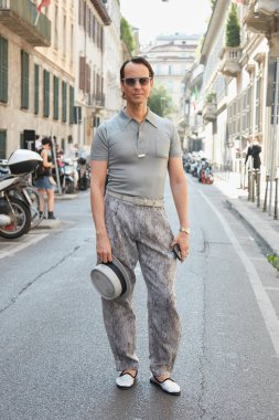 MILAN, İtalya - 20 Haziran 2022: Gri polo gömlekli ve şapkalı adam Giorgio Armani defilesinden önce, Milan Moda Haftası tarzı