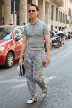 MILAN, İtalya - 20 Haziran 2022: Gri polo gömlekli ve şapkalı adam Giorgio Armani defilesinden önce, Milan Moda Haftası tarzı