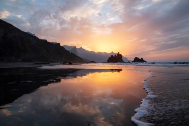 Benijo sahilini yıkan sakin dalgalara yansıyan muhteşem alacakaranlık ya da Playa de Benijo, doğadaki güzelliğin, uzaklığın ve izolasyonun gerçek bir temsilcisi, Tenerife, Kanarya Adaları, İspanya