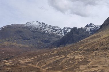 Black Cuillin dağlarını çevreleyen donmuş manzara, soğuk uzaylı doğası karla kaplı dramatik zirveler Peri havuzlarına uzanan kurak yürüyüş yolunu takip ediyor, Glen Brittle, Skye Adası, İskoçya