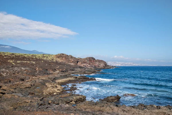 テネリフェ島 カナリア諸島 スペインの明確な海の波と山脈とエルソコロ町の景色を持つプエルティト ギマールで マルパイスとして知られている大まかな火山の土地を通過します — ストック写真