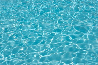 Swimming pool water ripples background, clean blue seiche waves in a spacious outdoor piscina, concept for summer vacation mood, tropical or hot destination holidays or traveling to an exotic location