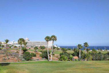 Amarilla Golf, Tenerife, Kanarya Adaları, İspanya - 10 Haziran 2022 öğleden sonra tropikal ağaçlar ve doğal engellerle çevrili büyük ve düzenli golf sahalarının ve yakındaki Golf del Sur tatil beldesinin manzarası