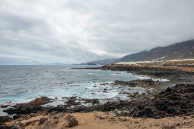Dağları kaplayan dramatik bulutlar, volkanik dalgalar ve İspanya 'nın Kanarya Adaları, Tenerife Adası' nın kuzey kıyısındaki sakin atmosferi silip süpürüyor.