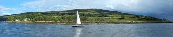 Segelbåt på ett skotskt loch, vackra kullar i bakgrunden — Stockfoto