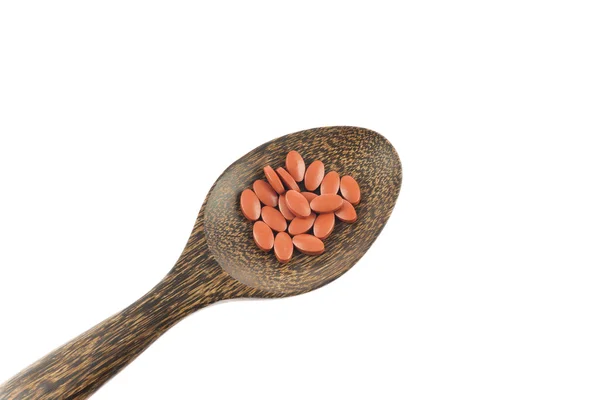Red pills on wooden spoon — Stock Photo, Image