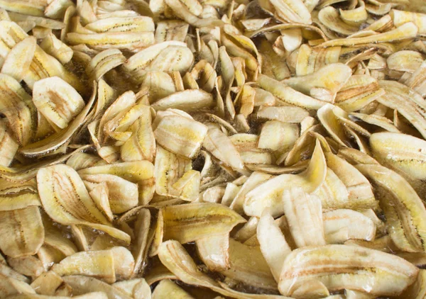 Making dried banana chips in hot pan — Stock Photo, Image