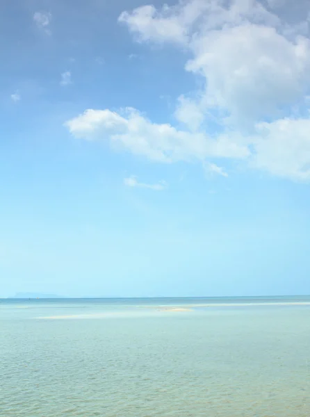 Paisaje marino con nubes blancas hinchadas, arena y cielo azul — Foto de Stock