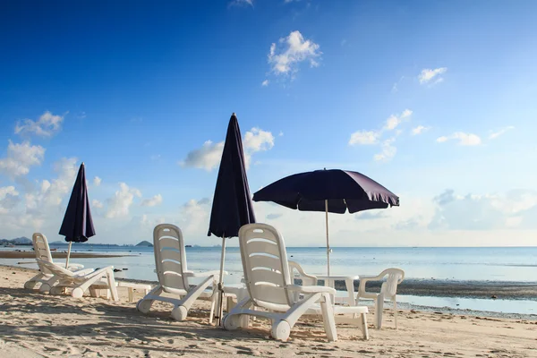 Cadeiras de praia e guarda-chuvas na bela praia de areia tropical — Fotografia de Stock