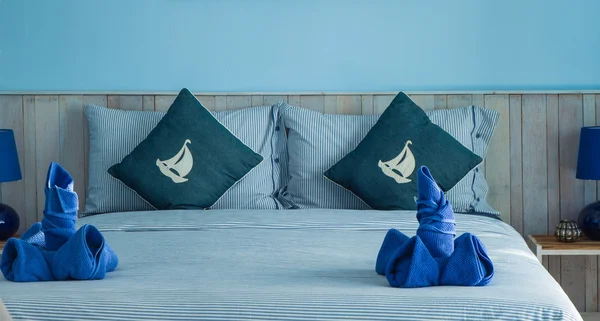 Голубое полотенце декореция на голубой кровати гостиничный номер — стоковое фото