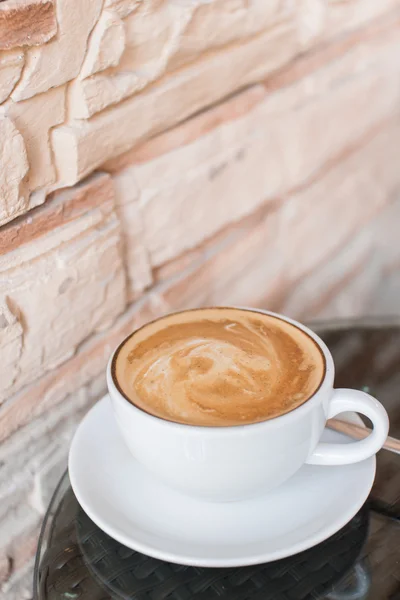 Hett kaffe latte cup på glasbord — Stockfoto