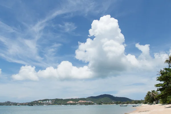 Облака над островом и зеленым океаном — стоковое фото