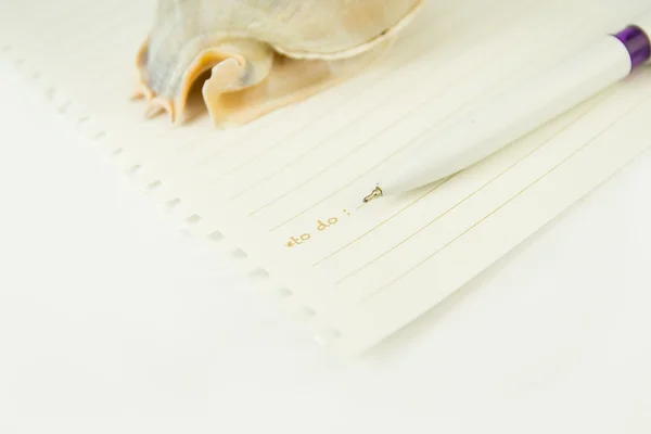Бумажная записка с ручкой и ракушкой — стоковое фото