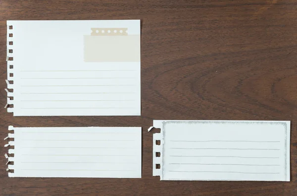 Sammlung weißer Notizpapiere auf Grunge-Holz — Stockfoto