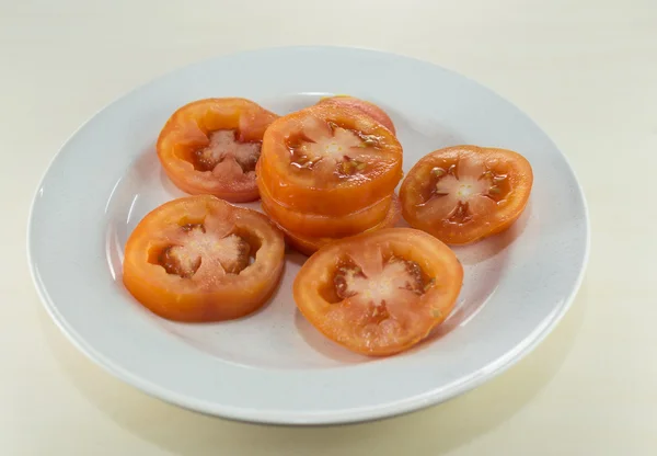 Tomato slice on white plate — Stock Photo, Image