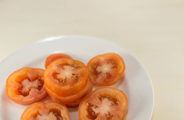 Tomaat slice op witte plaat — Stockfoto