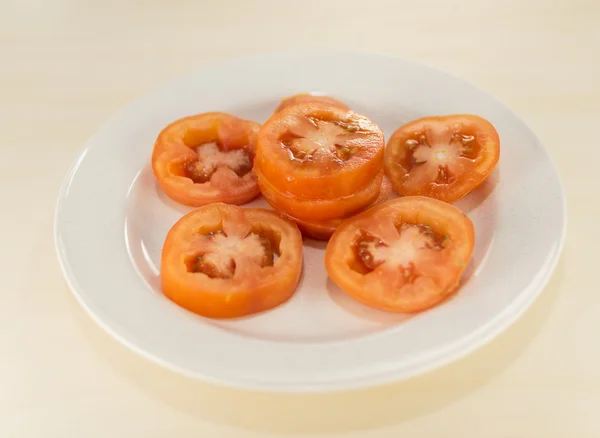 Rebanada de tomate en plato blanco — Foto de Stock