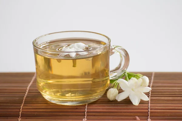 Чашка жасминового чая и цветка — стоковое фото