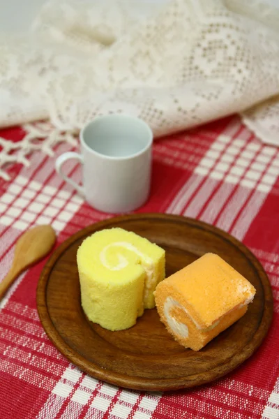 Jam roll in wooden dish and coffee cup — Stock Photo, Image