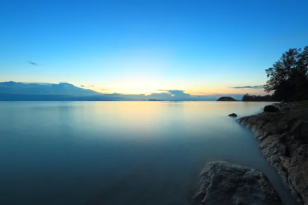 Puesta de sol de paisaje marino de larga exposición con fantástica superficie rocosa — Foto de Stock