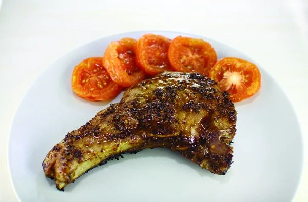 Costeleta de porco com grelha de tomate — Fotografia de Stock