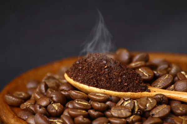 Kaffebønner og malet kaffe på træske med grunge backg - Stock-foto
