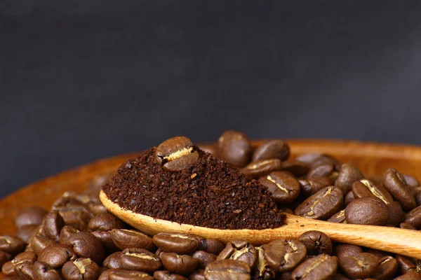 Coffee beans and ground coffee on wooden spoon with grunge backg — Stock Photo, Image