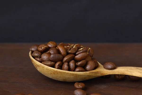 Granos de café sobre cuchara de madera con fondo grunge —  Fotos de Stock
