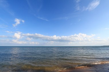 panoramisch zeegezicht met gezwollen witte wolken, blauwe hemel en groen oc
