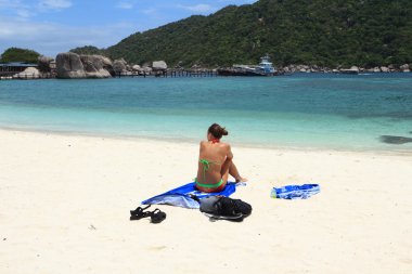 Bikinili kadın sahilde dinleniyor.